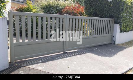 Braune Tür, graues Aluminium, modernes Schiebetor-Heimportal des Stadthauses in einem Vorort Stockfoto