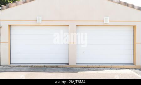 Modernes, doppeltüriges Privathaus mit weißer Garage und weißem Eingang Stockfoto