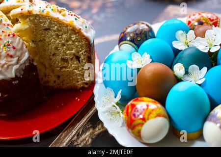 Das Fest der Heiligen Ostern. Bemalte Eier und Osterkuchen auf Platten. Stockfoto