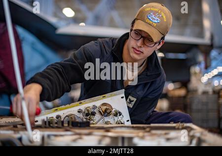 220901-N-XR893-1111 ATLANTIK (SEP. 1, 2022) Aviation Support Equipment Technician 3. Klasse Adam Titterall, aus Phillipsburg, New Jersey, entfernt die Schutzschalter-Verkleidung eines Speckers im Hangarbereich der USS Harry S. Truman (CVN 75), 1. September 2022. Die Harry S. Truman Carrier Strike Group befindet sich im geplanten Einsatzgebiet der US Naval Forces Europe und wird von der Sechsten Flotte der USA eingesetzt, um die Interessen der USA, der Alliierten und der Partner zu verteidigen. Stockfoto