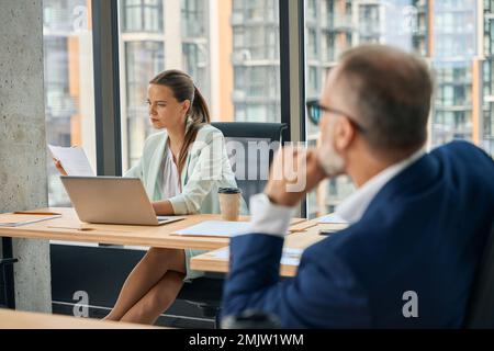 Zwei Büromitarbeiter teilen sich das Büro und konzentrieren sich auf die Arbeit Stockfoto