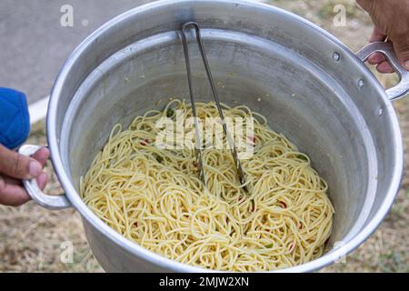 Eine Pfanne enthält Pasta in einer cremigen weißen Sauce mit Fischstücken, die wahrscheinlich in Butter sautiert und mit Kräutern und Gewürzen gewürzt sind. Die Pasta kann eine sein Stockfoto