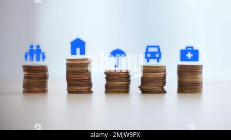 Münzstapel, Spar- und 3D-Zeichen für Versicherung, finanzielle Sicherheit und Zukunftsplanung zu Hause. Investitionen, Geld und Bargeld mit Familie, Haus und Stockfoto