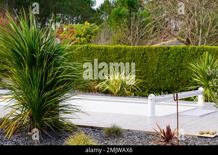 Haus Swimmingpool im Gartenhaus mit starrer Poolabdeckung auf Rolle aufgerollt Stockfoto