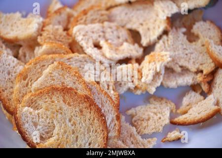 Nahaufnahme von Brotstücken auf weißem Hintergrund. Stockfoto
