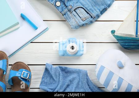 Flach liegend mit Spielzeugkamera des kleinen Fotografen auf weißem Holzhintergrund Stockfoto