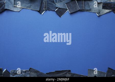 Rahmen aus ausgeschnittenen Jeans auf blauem Hintergrund, Draufsicht. Platz für Text Stockfoto