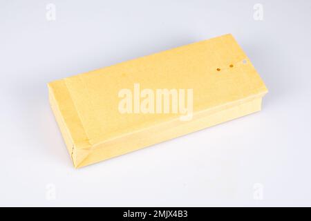 Brauner, quadratischer Papierumschlag mit perforiertem Verschluss auf weißem Hintergrund Stockfoto