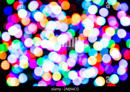 Mehrfarbige Lichtkreise auf schwarzem Hintergrund. Farbenfrohes Bokeh vor der Kulisse Stockfoto