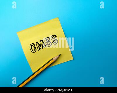 Stift und Haftnotiz mit dem Wort CMSS auf blauem Hintergrund. Stockfoto