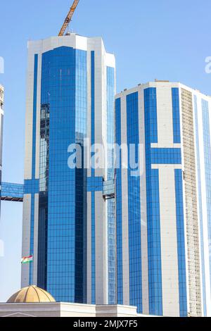 DUSCHANBE, TADSCHIKISTAN - 12. AUGUST 2022: Neue blaue Wolkenkratzer auf der Rudaki Avenue werden gegen den Himmel gebaut. Stockfoto