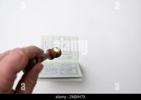 Ein deutscher Pass auf weißem Hintergrund und ein Stempel daneben. Schengen-Visum. Ein Visum und ein Visum zu erhalten Stockfoto