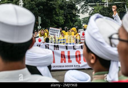 Bogor, Indonesien. 27. Januar 2023. Indonesische Muslime nehmen an einem Protest gegen Schwedisch-Dänisch Teil, um die jüngste Schändung des heiligen islamischen Buches Koran durch einen rechtsextremen Politiker Rasmus Paludan in Bogor, West-Java, Indonesien, am 27. Januar 2023 anzuprangern. Die globale islamische Gemeinschaft verurteilte Islamfeindlichkeit, nachdem der schwedisch-dänische rechtsextreme Politiker Rasmus Paludan bei einer Kundgebung in Stockholm am 21. Januar eine Kopie des Korans verbrannte. (Foto: ANDI M RIDWAN/INA PHOTO AGENCY/SIPA USA) Guthaben: SIPA USA/Alamy Live News Stockfoto