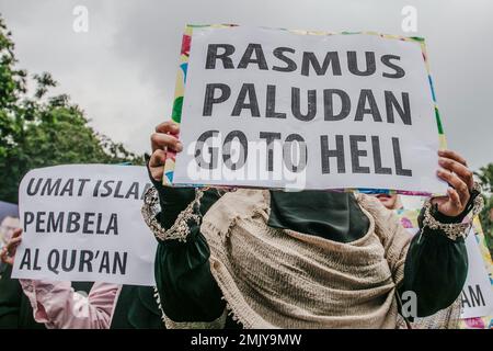 Bogor, Indonesien. 27. Januar 2023. Indonesische muslimische Frauen halten während eines Protests gegen Schwedisch-Dänisch ein Plakat, um die jüngste Entweihung des heiligen islamischen Buches Koran durch einen rechtsextremen Politiker Rasmus Paludan in Bogor, West-Java, Indonesien, am 27. Januar 2023 anzuprangern. Die globale islamische Gemeinschaft verurteilte Islamfeindlichkeit, nachdem der schwedisch-dänische rechtsextreme Politiker Rasmus Paludan bei einer Kundgebung in Stockholm am 21. Januar eine Kopie des Korans verbrannte. (Foto: ANDI M RIDWAN/INA PHOTO AGENCY/SIPA USA) Guthaben: SIPA USA/Alamy Live News Stockfoto