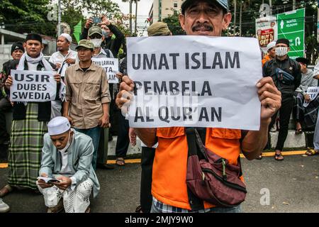 Bogor, Indonesien. 27. Januar 2023. Ein indonesischer Moslem hält während eines Protests gegen Schwedisch-Dänemark ein Plakat, um die jüngste Entweihung des heiligen islamischen Buches Koran durch einen rechtsextremen Politiker Rasmus Paludan in Bogor, Westjava, Indonesien, am 27. Januar 2023 anzuprangern. Die globale islamische Gemeinschaft verurteilte Islamfeindlichkeit, nachdem der schwedisch-dänische rechtsextreme Politiker Rasmus Paludan bei einer Kundgebung in Stockholm am 21. Januar eine Kopie des Korans verbrannte. (Foto: ANDI M RIDWAN/INA PHOTO AGENCY/SIPA USA) Guthaben: SIPA USA/Alamy Live News Stockfoto