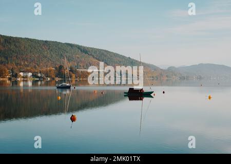 Segelboote am Wörthersee im Süden Österreichs im Herbst. Malerisches Landschaftspanorama am Wasserrand. Stockfoto