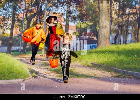 Ein Junge in Skelettkostüm und Familie mit Halloween-Verkleidung Stockfoto