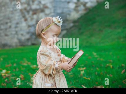 Charmantes Baby im Prinzessinnen-Kostüm mit Krone auf dem Kopf Stockfoto