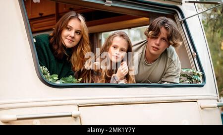 Kinder, Familie, Bruder Schwester, die im Wohnmobil reist, Haus auf Rädern. Wohnwagen Wohnwagen. Blick in Fenster. Lustige Fahrt auf der Straße. Campingbus über Nacht. Wan Stockfoto