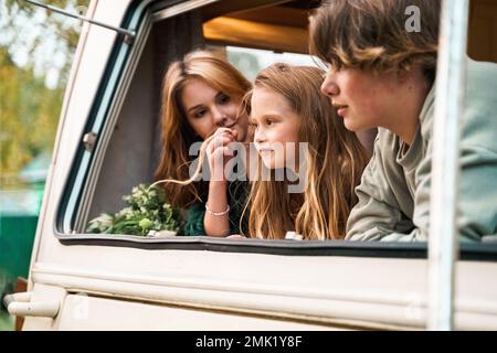 Kinder, Familie, Bruder Schwester, die im Wohnmobil reist, Haus auf Rädern. Wohnwagen Wohnwagen. Blick in Fenster. Lustige Fahrt auf der Straße. Campingbus über Nacht. Wan Stockfoto