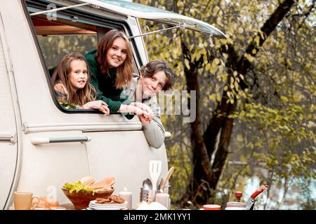 Kinder, Familie, Bruder Schwester, die im Wohnmobil reist, Haus auf Rädern. Wohnwagen Wohnwagen. Blick in Fenster. Lustige Fahrt auf der Straße. Campingbus über Nacht. Wan Stockfoto