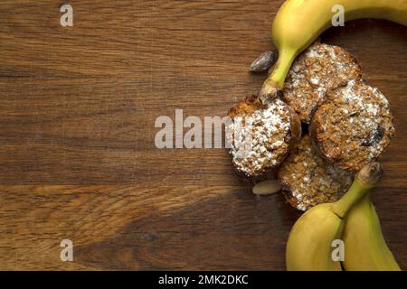 Frisch gebackene Bananen Muffins Top View auf Holzhintergrund mit Kopierraum, gesunde vegane Cupcakes, Diät vegetarisches Konzept Stockfoto