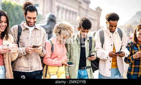 Multikulturelle glückliche Freunde, die auf dem Campus des Colleges Spaß mit Mobiltelefonen haben - Tech Life Style Konzept mit jungen Jungs und Mädchen Stockfoto