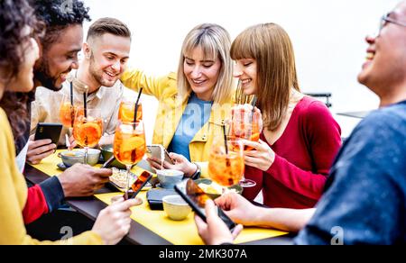 Junge Freunde erzählen Fotogeschichten im Cocktailbar-Restaurant - Lifestyle-Konzept mit Leuten, die Spaß an einem schicken Ort zur Happy Hour haben Stockfoto