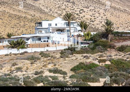 Moderne Residenz, alle in Weiß, auf der Seite eines Hügels am Rande des Sotavento Strandes erbaut. Stockfoto