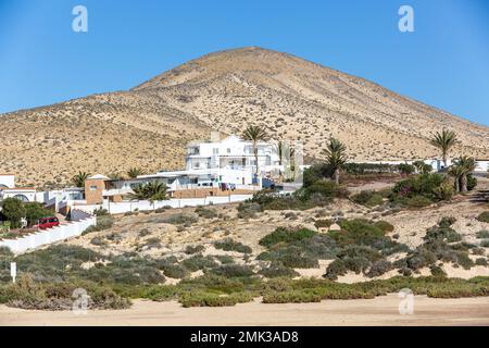 Moderne Residenz, alle in Weiß, auf der Seite eines Hügels am Rande des Sotavento Strandes erbaut. Stockfoto