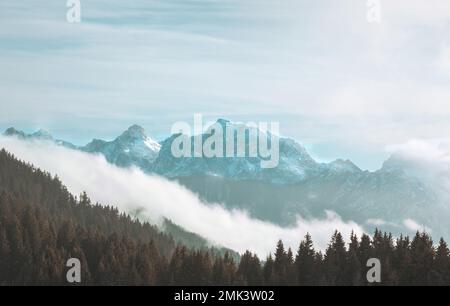Panoramablick auf die schneebedeckten Berge zwischen Österreich, Slowenien und Italien. Gipfel der slowenischen Alpen, bewölktes Wetter. Stockfoto