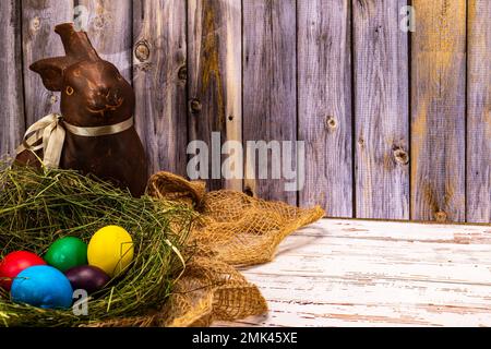 Osterhase mit Nest und bunten Ostereiern im Stall Stockfoto