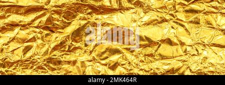 Konsistenz zerknitterter, zerknitterter Folie von goldener, gelber Farbe. Folienbanner-Website Stockfoto