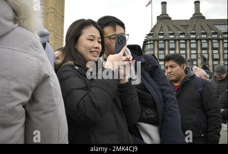 London, England, Großbritannien. Ein junges asiatisches Paar, das für ein Selfie auf der Westminster Bridge posiert. Stockfoto