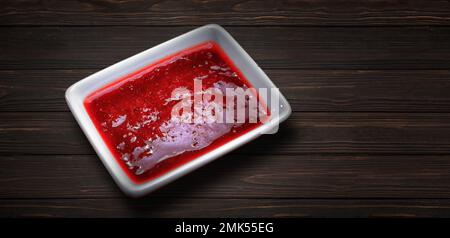 Erdbeersoße in einer Pfanne mit weißer Soße auf Holzhintergrund Stockfoto