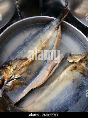 Ein paar Bücken, die in einer Bratpfanne aus Edelstahl pochen Stockfoto