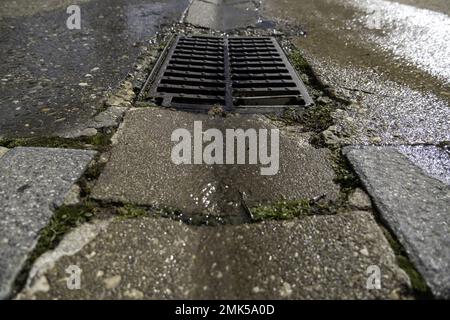 Kanalisation mit Wasser in städtischem Boden, Entwässerung und Regen Stockfoto