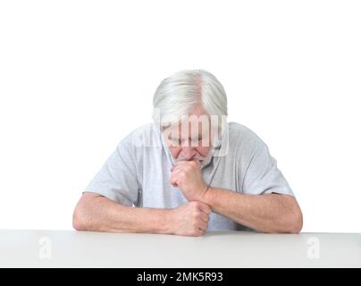 Horizontale Aufnahme eines weißhaarigen alten Mannes, der an einem Tisch sitzt und seinen Kopf in Trauer, Sorge oder Gebet auf die Hände lehnt. Isoliert auf weiß. Viele Polizisten Stockfoto