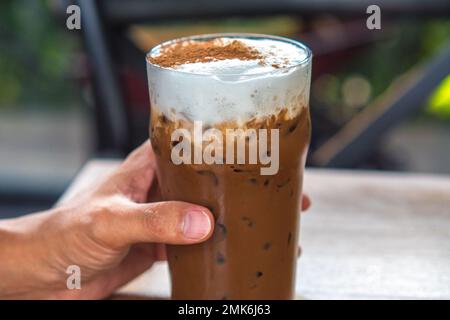 Halten Sie Eisschokolade oder Kakao Latte in Glas Stockfoto