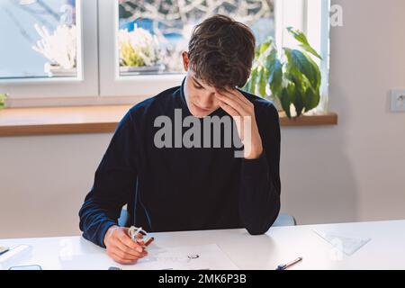 Unternehmer und Architekt denken intensiv über ein neues Design für einen neuen Prototyp nach, den er mit Bleistift auf Papier zeichnet. Ein neues Design erfinden. Ein Muster Stockfoto