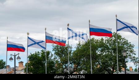 Fahnenmasten mit Russisch und St. Andrews Flaggen auf dem Ufer in St. Petersburg Stockfoto