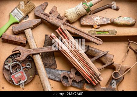 Alte rostige Werkzeuge wie Hammer, Zangen, Meterstab, Nivellierung, Schraubenschlüssel, Säge, Axt, Pinsel, Deutschland Stockfoto