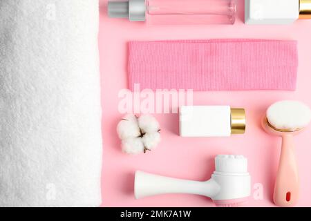 Flache Laienzusammensetzung mit Gesichtsreinigungsbürsten auf pinkfarbenem Hintergrund. Kosmetische Werkzeuge Stockfoto