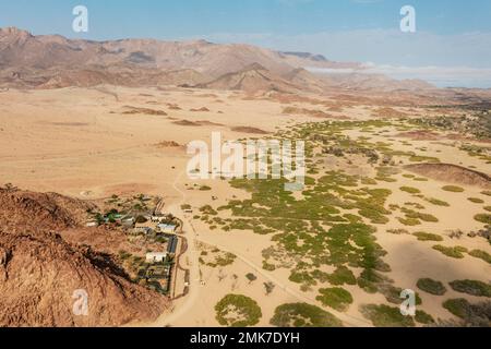 Die Brandberg White Lady Lodge am Rand des trockenen Flussbettes des Ugab, im Hintergrund der Brandberg, Namibias höchster Berg Stockfoto