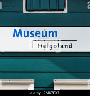 Schild mit Inschrift Museum Helgoland auf blaugrüner Hausmauer, Insel Helgoland, Schleswig-Holstein, Deutschland Stockfoto