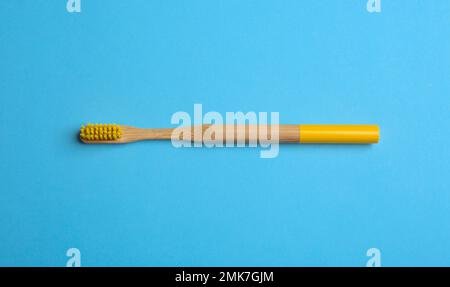 Zahnbürste aus Bambus auf hellblauem Hintergrund, Draufsicht Stockfoto