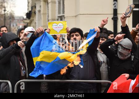 London, England, Großbritannien. 28. Januar 2023. Muslimische Demonstranten verbrennen vor der Londoner Botschaft Schwedens die schwedische Flagge, nachdem der rechtsextreme Politiker und Provokateur gegen den Islam, Rasmus Paludan, eine dänisch-schwedische Doppelgängerin vor der türkischen Botschaft in Stockholm Koran verbrannt hat. (Kreditbild: © Thomas Krych/ZUMA Press Wire) NUR REDAKTIONELLE VERWENDUNG! Nicht für den kommerziellen GEBRAUCH! Kredit: ZUMA Press, Inc./Alamy Live News Stockfoto