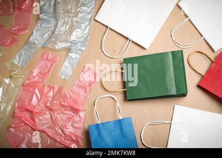 Flache Laienzusammensetzung mit Kunststoff- und Papierbeuteln auf beigefarbenem Hintergrund. Recycling-Konzept Stockfoto