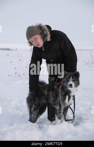 Kalter Wintertag mit meinem Akita Inn Hund auf gefrorenem Meer in Kotka, Finnland. Viel Schnee und kalter Wind Stockfoto