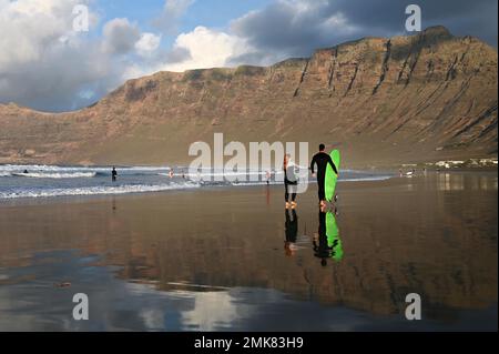 Surfer am Strand von Caleta de Famara, Playa de Famara, Lanzarote, Spanien Stockfoto